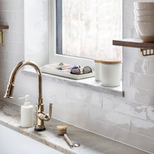 Load image into Gallery viewer, kitchen sink with white ceramic pump dispenser, white ceramic jars with wood lids and white ceramic trays organizing personal items