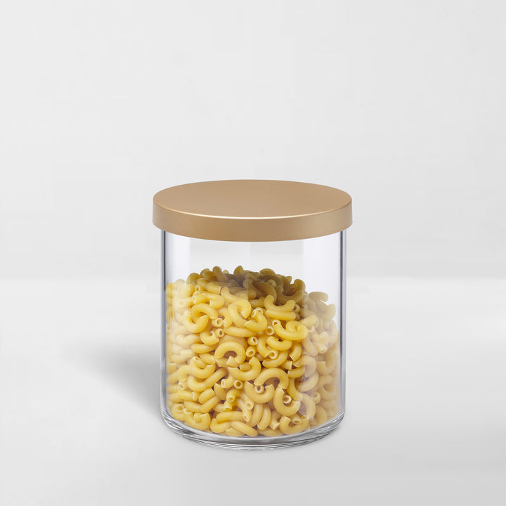 transparent storage canister with gold lid holding pasta