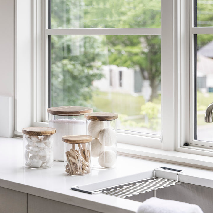laundry room with glass jars with acacia wood lids holding laundry supplies like detergent, dryer balls and clothes pins