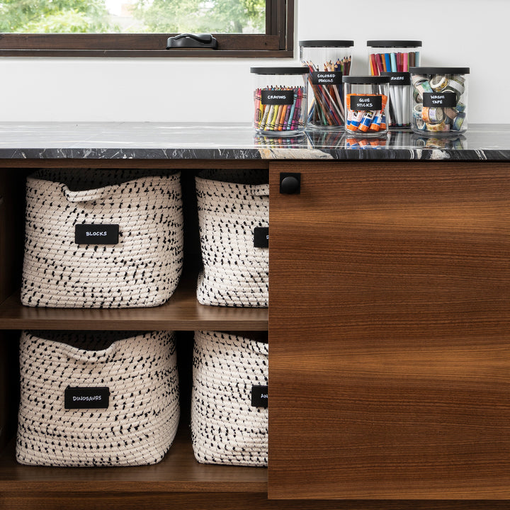 playroom cabinet with baskets and hand written black removable labels for organizing