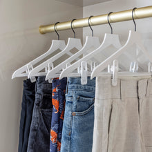 Load image into Gallery viewer, white slim, non-slip suit hangers with black hooks holding shorts
