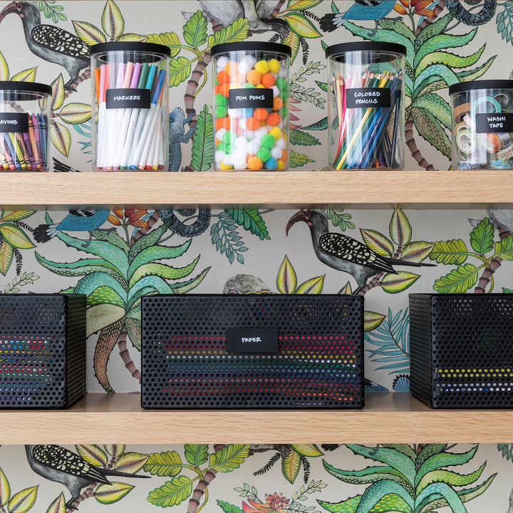 playroom shelving with canisters and black metal baskets labeled with hand written black removable labels