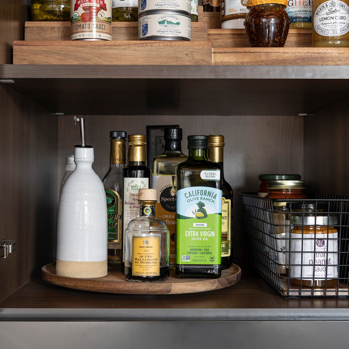 acacia wood turntable, lazy susan on pantry shelf holding oils