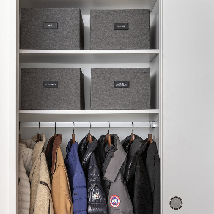 coat closet with dark grey fabric bins organized with black removable pre-printed labels