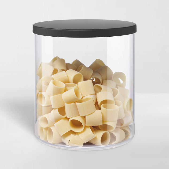 transparent storage canister with black lid holding pasta