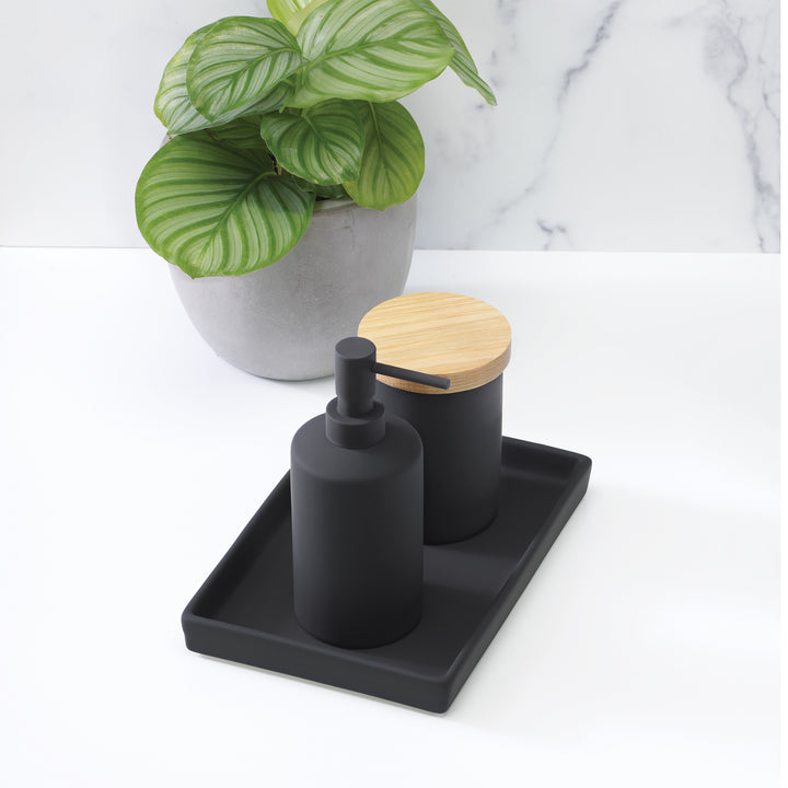 bathroom countertop with black ceramic set including tray, jar with wood lid and liquid pump dispenser