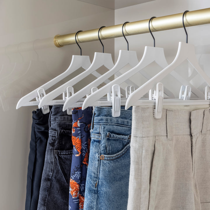 white slim hangers with black hooks holding shorts in a closet