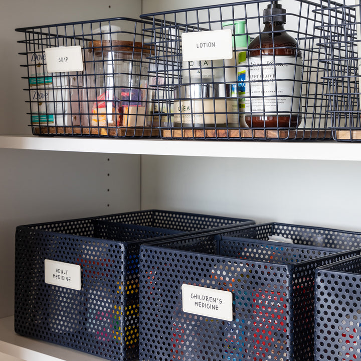 blue metal baskets holding bathroom products with white removable labels